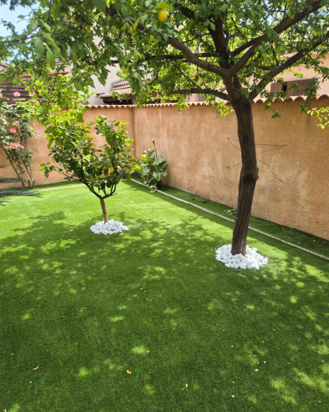 Aménagement de jardin avec pose de gazon synthétique et galets blancs à la Crau dans le Var